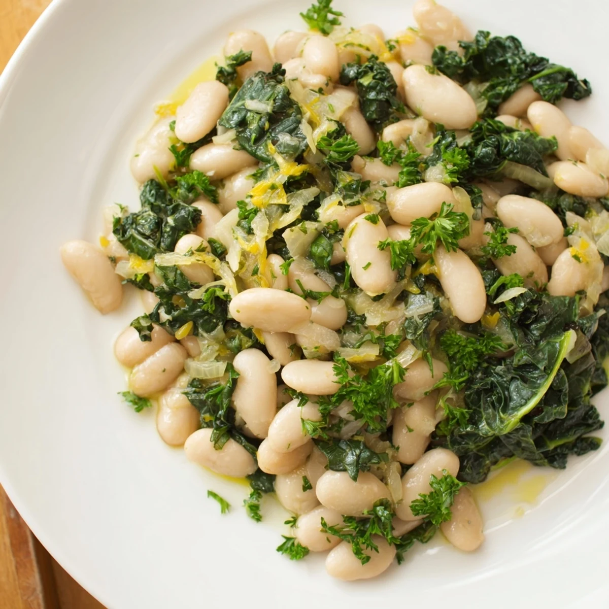 A warm bowl of Garlicky Beans with Winter Greens, showing tender greens and creamy beans, a hearty meal.
