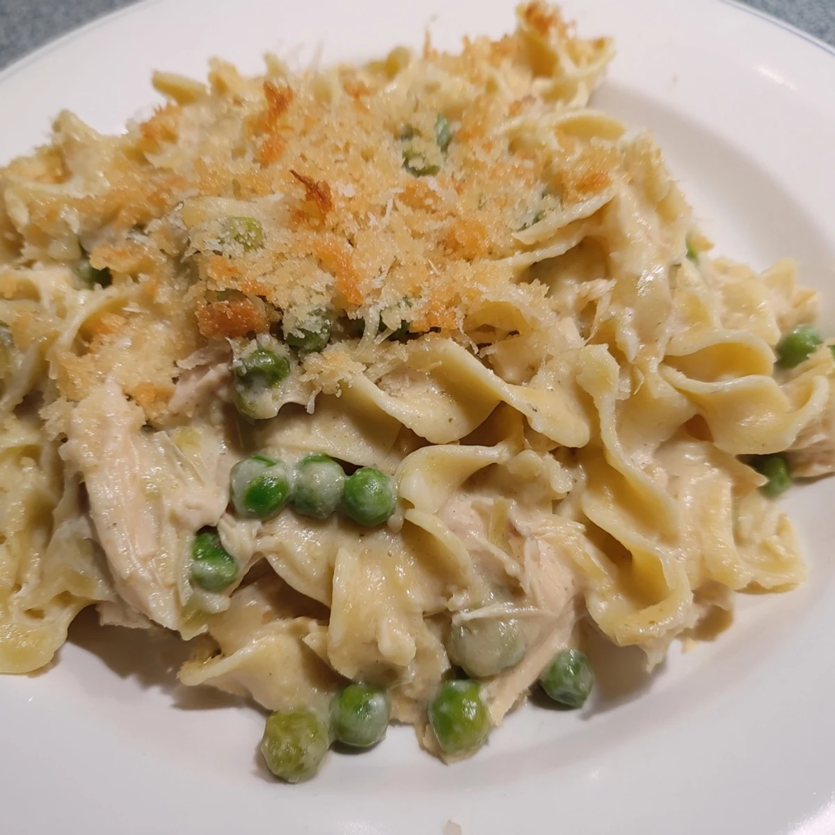 Golden, bubbly Creamy Tuna Noodle Casserole with a crispy Ritz cracker topping, ready to serve.