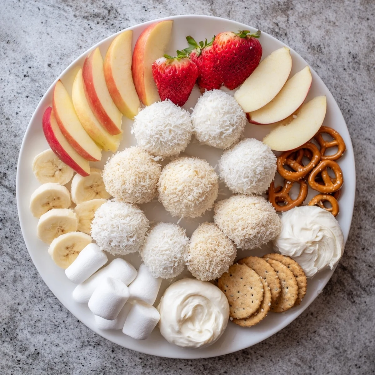 Creamy Marshmallow Snowball Dip Platter, a delightful dessert with vibrant fruits and crunchy pretzels.