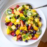 This Tropical Pineapple Fruit Boat shows a refreshing fruit salad with bright kiwi and strawberries.