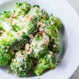 Creamy Garlic Parmesan Broccoli Salad tossed with cherry tomatoes and crunchy toasted almonds, served chilled.