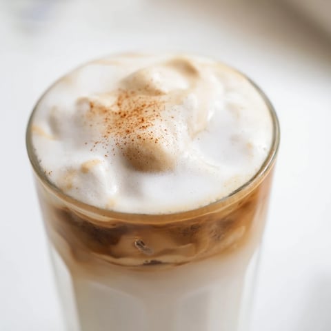 Fluffy brown sugar dalgona latte, a beautiful whipped coffee cloud atop cold milk and ice.
