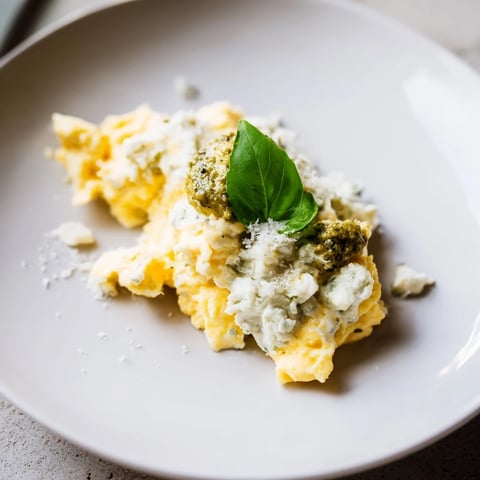 Fluffy Pesto Cottage Cheese Eggs, a vibrant breakfast, garnished with fresh basil and Parmesan cheese.