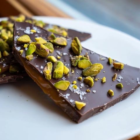 A close-up of Pistachio Salted Caramel Bark showcases the decadent layers with crunchy pistachios.