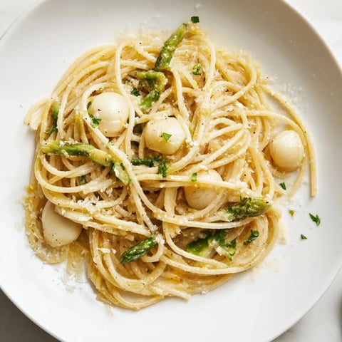 Golden roasted garlic and crisp asparagus tossed with al dente spaghetti and Parmesan in a skillet.  