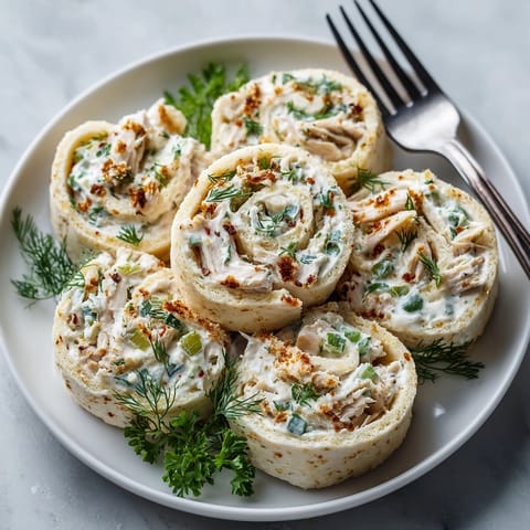 Freshly sliced Dill Pickle Ranch Chicken Pinwheels showcasing the creamy ranch and pickle-filled chicken snack.
