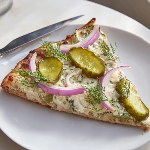 Deliciously unique Pickle Pizza garnished with fresh dill and zesty lemon flavors.  