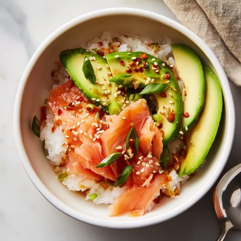 Microwave-steamed leftover salmon and rice bowl garnished with sesame and ginger.  