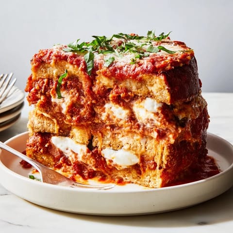 Comforting Eggplant Parmesan Lasagna topped with golden cheese, perfect for family gatherings.  