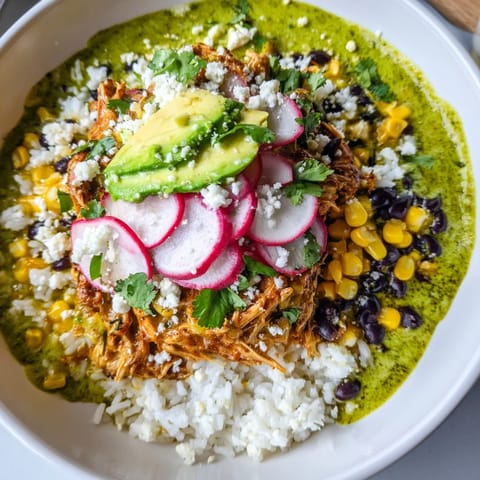 Enjoy a visually appealing Green Enchiladas Rice Bowl: vibrant ingredients like avocado and cilantro, ready to eat.