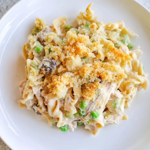 Warm, creamy tuna noodle casserole with a buttery, golden-brown Ritz cracker crust, bubbling hot.