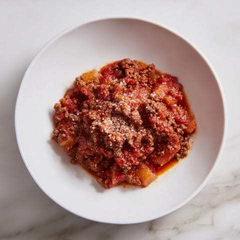 A close-up of the robust Classic Tuscan Ragu simmering slowly in a large pot.
