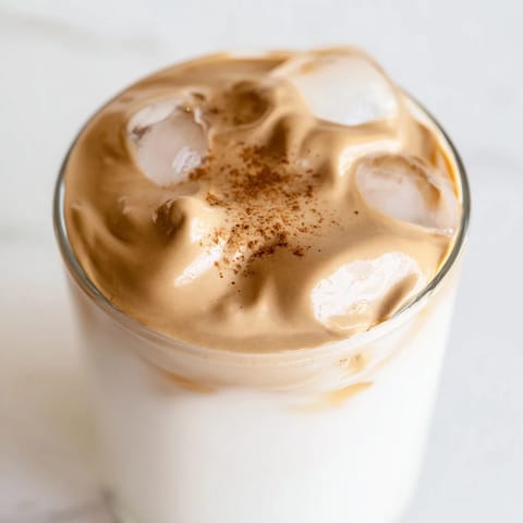 The perfect homemade brown sugar dalgona latte, deliciously layered with foamy coffee and milk.