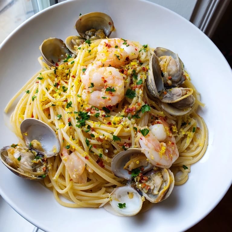 Delectable seafood pasta aglio e olio, showcasing plump shrimp and tender clams in a flavorful, garlicky sauce.